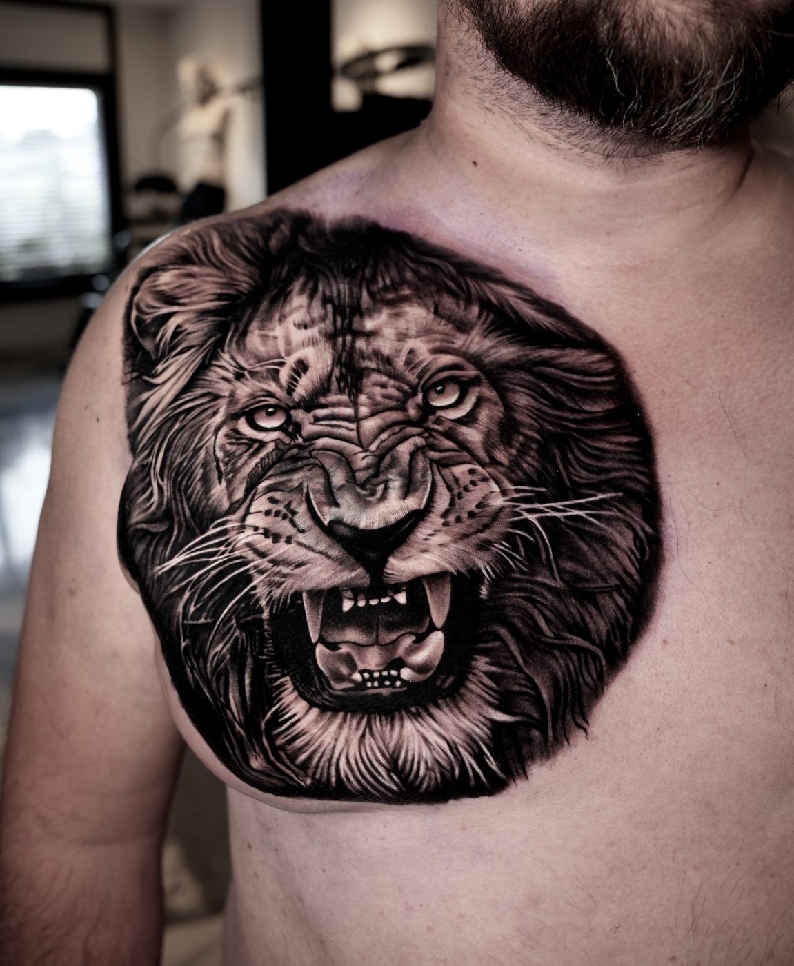 Tatuaje realista de león en el pecho