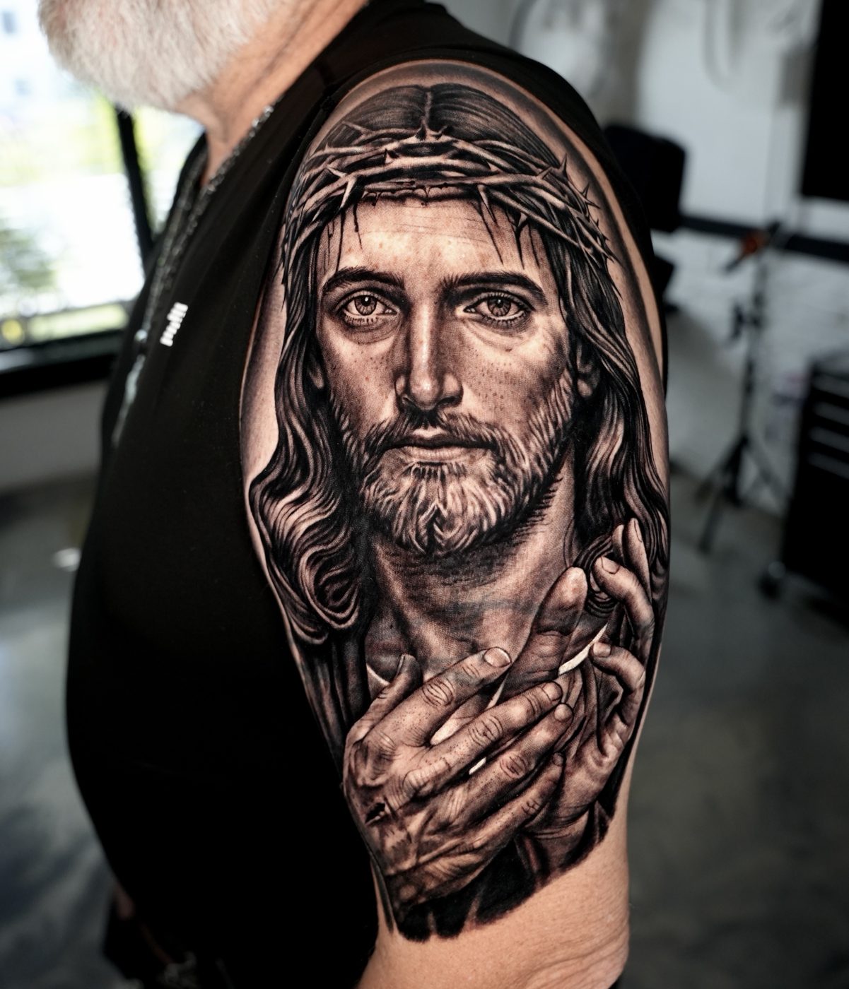 Retrato religioso en negro y gris en el hombro